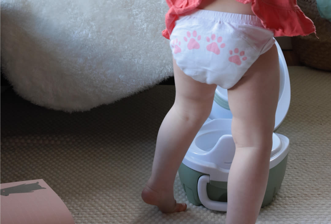 Litet barn med blöja ska testa pottan.