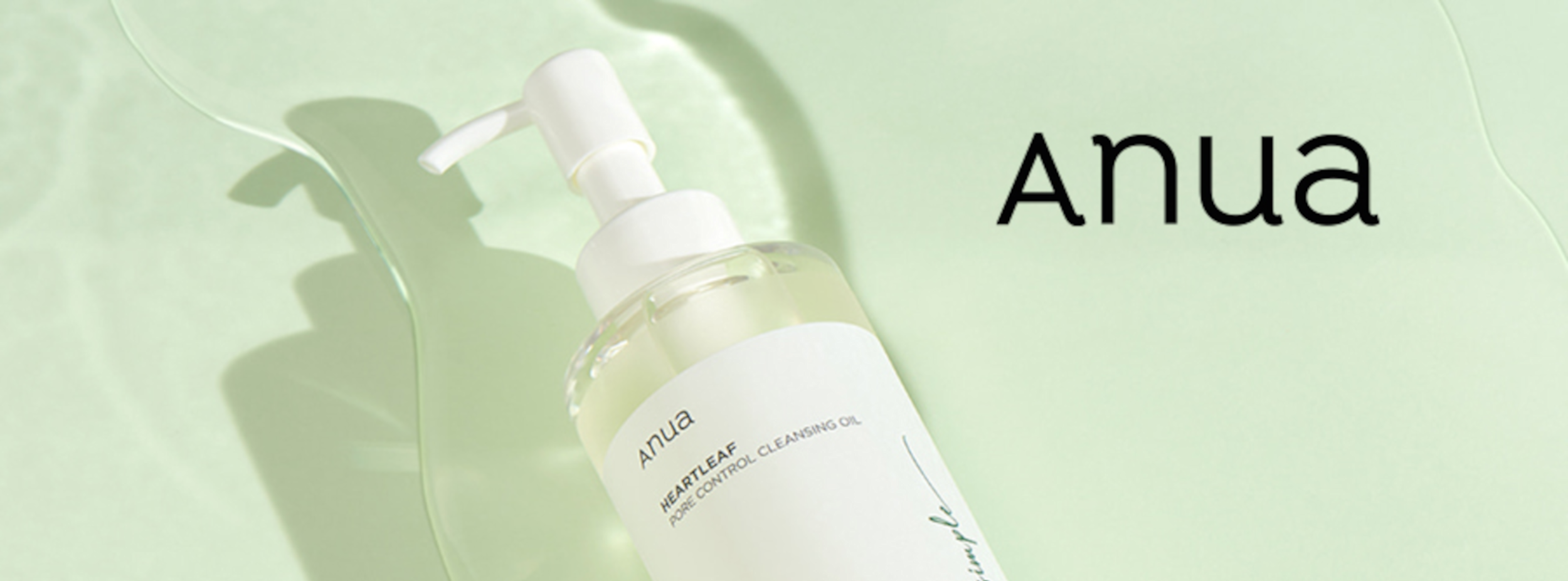 Flaska med pump märkt "Anua HEARTLEAF PORE CONTROL CLEANSING OIL" ligger på ljusgrön bakgrund med texten "Anua" bredvid.