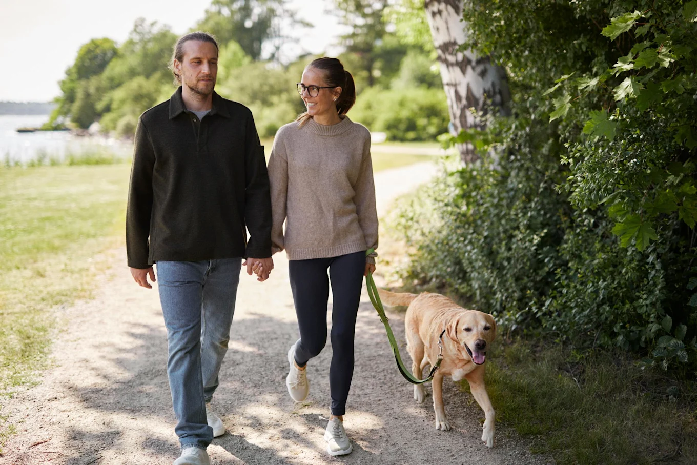 En man och en kvinna är ute och går med en hund.