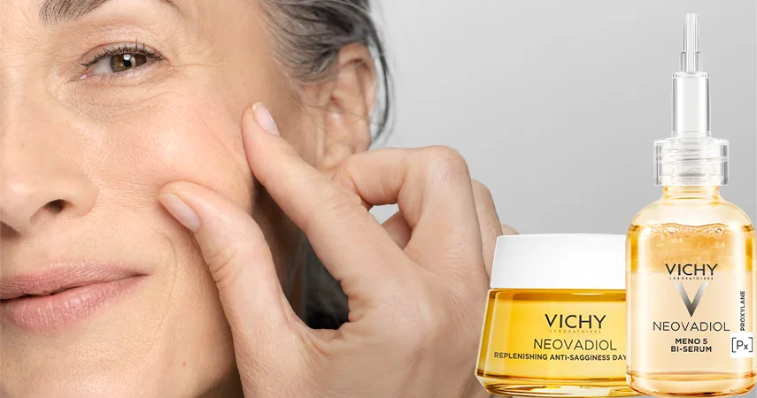 En äldre kvinna klämmer i huden på sin kind. Bredvid står två produkter från Vichy.
