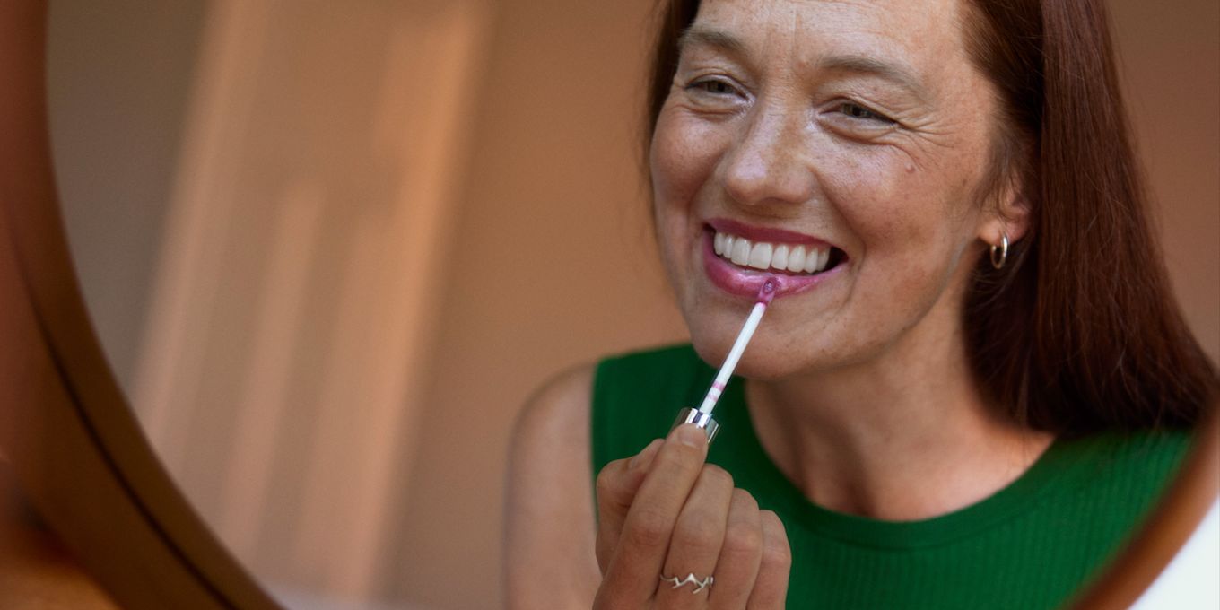 kvinna sminkar sig framför en spegel